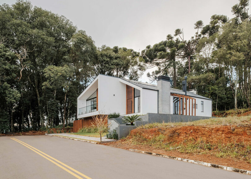 far view of modern home with angular exterior with vertical wood slat cladding and gray details